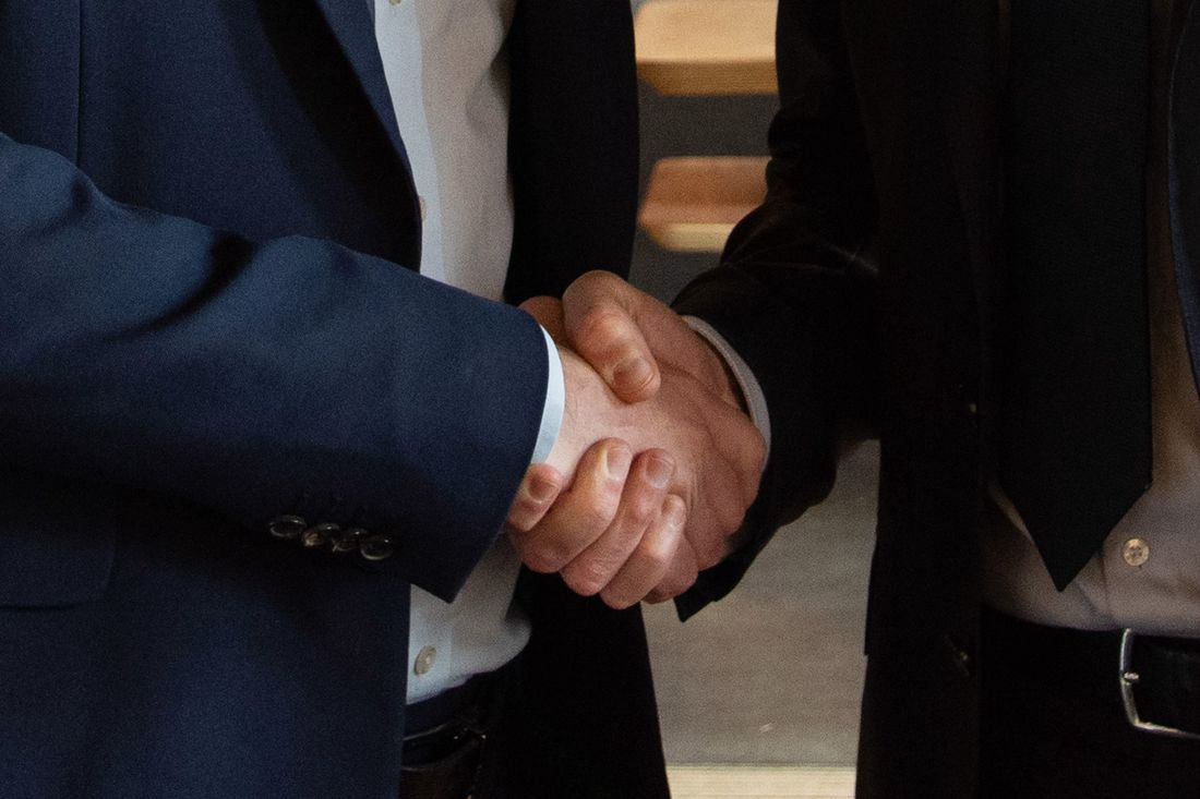 To personer giver hånd